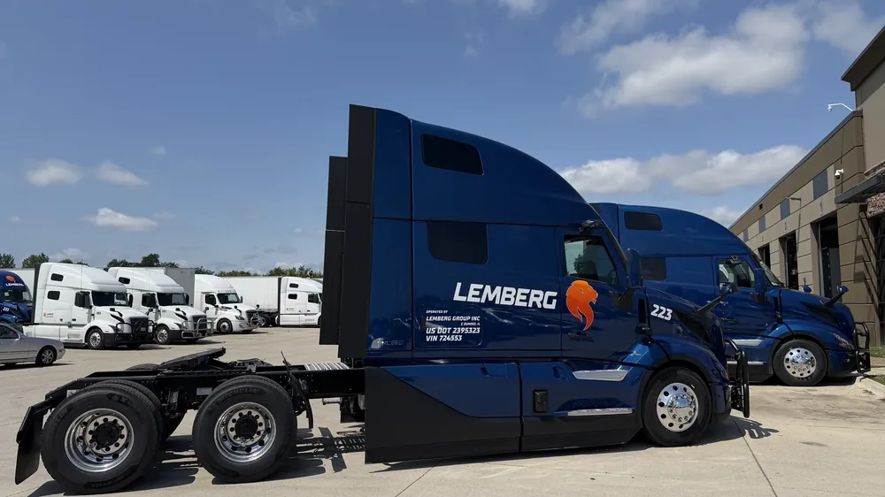 Lemberg Group tractors and dry van trailers staged in the yard